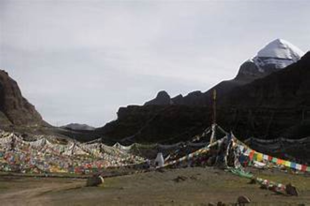 Spiritual view of Mount Kailash with prayer flags lining the pilgrimage path.