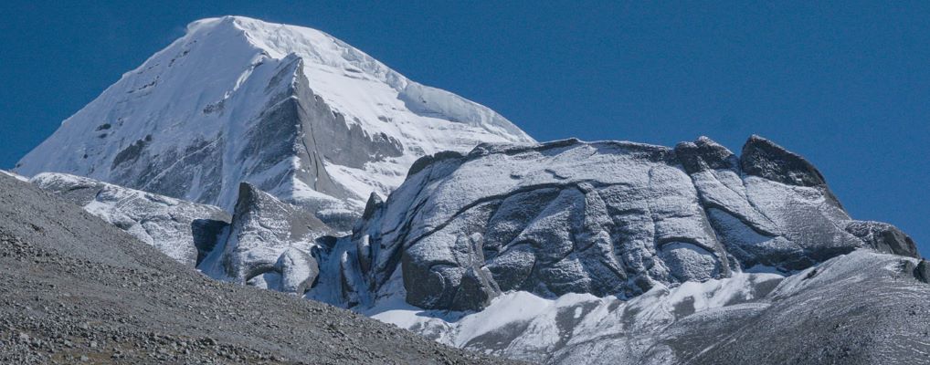 Snow-covered Mount Kailash peak under clear blue sky