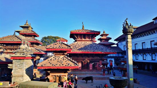 Traditional temples with tiered roofs in Kathmandu Durbar Square under a clear blue sky